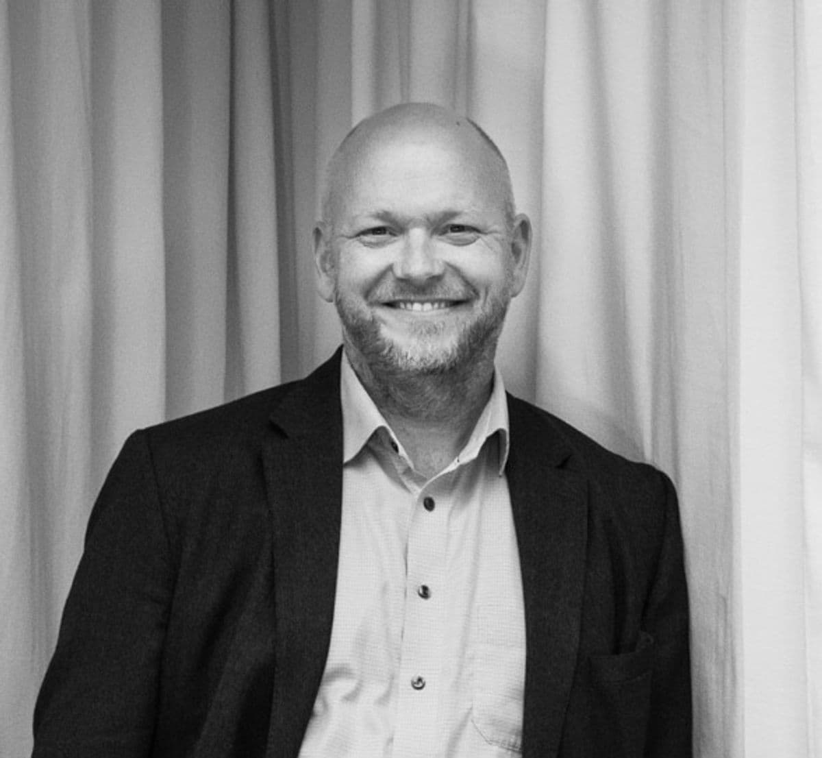 Black-and-white portrait of Jakob Holtze, Artistic Consultant at Mogens Dahl Concert Hall. The image presents a professional and contemplative depiction of Jakob Holtze, highlighting his role in advising and providing artistic guidance for the concert hall.