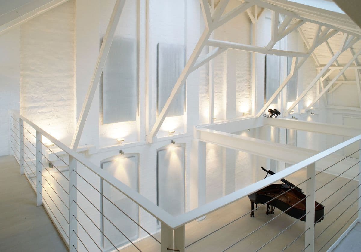 Photo taken from the balcony in the Concert Hall at Mogens Dahl Concert Hall, showing a piano positioned on the floor of the hall. The image provides a view of the elegant musical decor in the room.