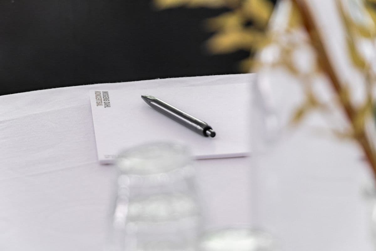 Close-up of a notebook and pen resting on a table during a conference at Mogens Dahl Concert Hall. The picture highlights the details of the professional conference facilities, where attendees have access to all necessary materials for effective note-taking and participation in the conference.