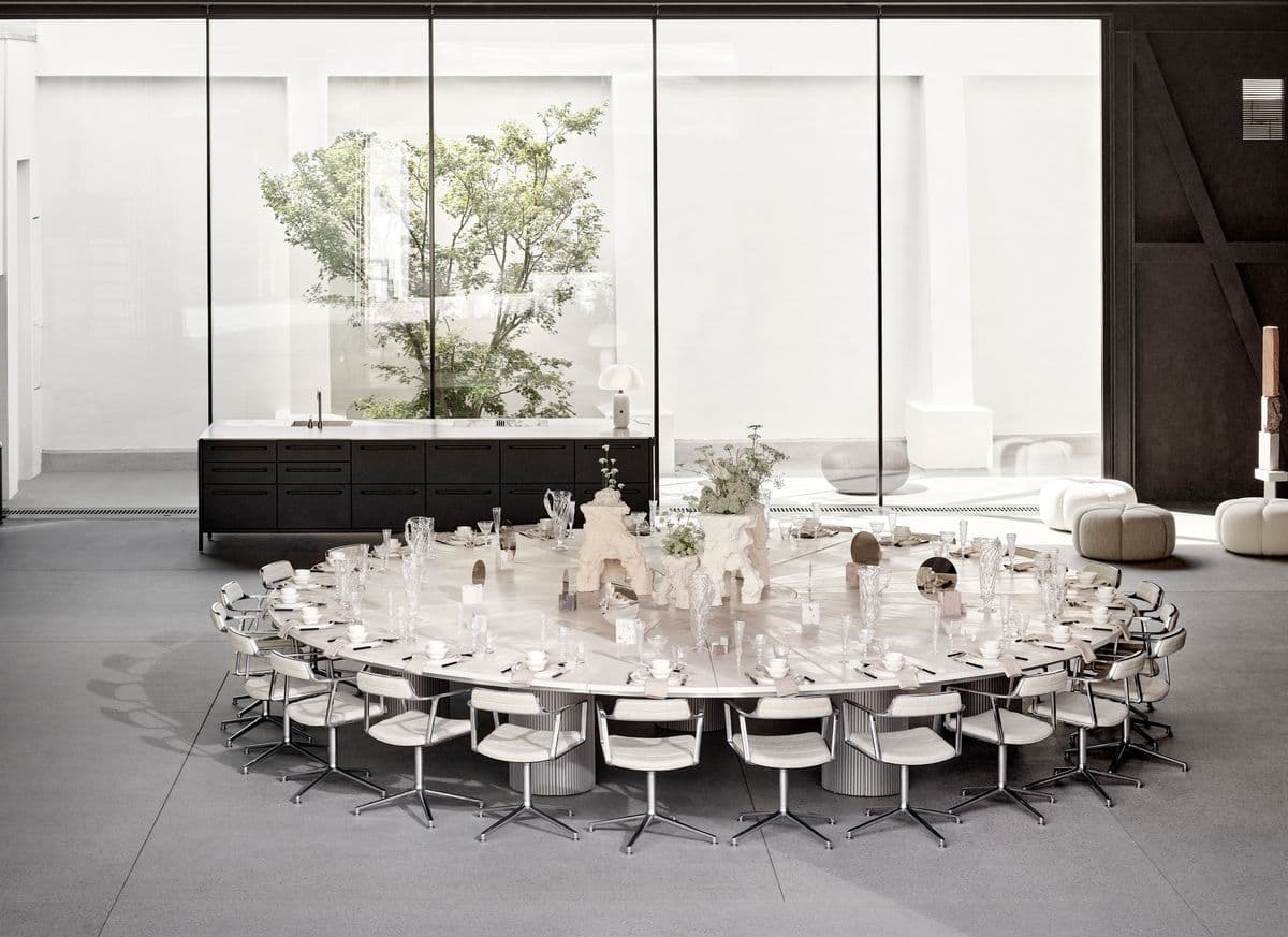 Large table set up and elegantly decorated in the Garage at Mogens Dahl Concert Hall, ready for an event. The picture showcases the raw, charming atmosphere of the Garage, which is perfect for weddings, corporate parties, and conferences. The space is flexibly arranged for both standing and seated events.