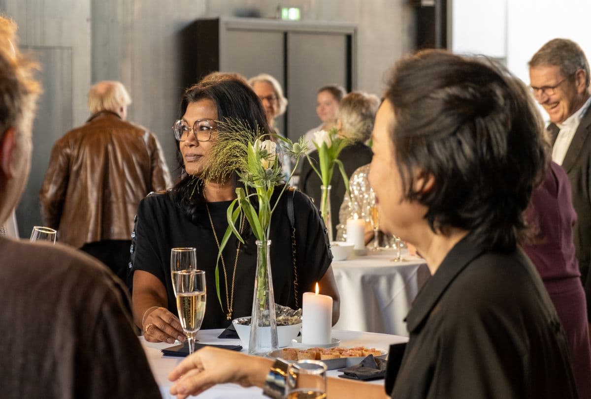 Gæster nyder en elegant middag ved et festligt bord under et event på Mogens Dahl Koncertsal, med fokus på en sofistikeret og afslappet atmosfære.