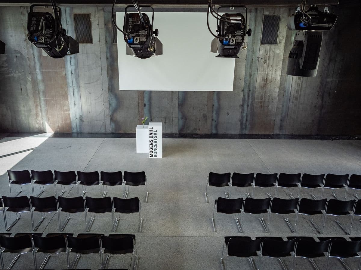 Chairs set up and ready for a conference in the Garage at Mogens Dahl Concert Hall. The picture shows a professional and organized arrangement of chairs in the raw yet stylish space, ideal for conferences and professional events. The Garage's flexible layout ensures an efficient and comfortable experience for attendees.