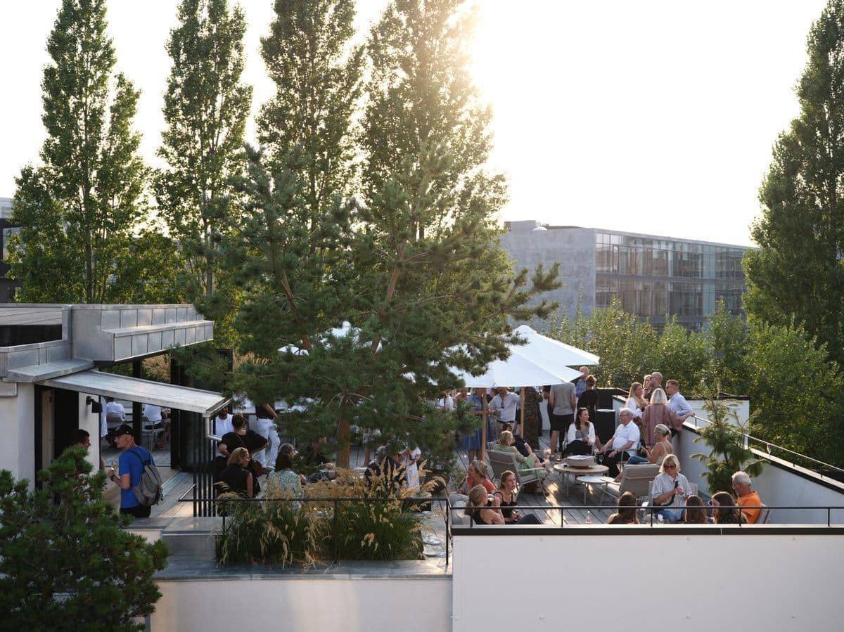 Photo of the Garage rooftop terrace filled with guests during an event at Mogens Dahl Concert Hall. The image shows the vibrant atmosphere and elegant outdoor setup, where guests are enjoying the occasion.